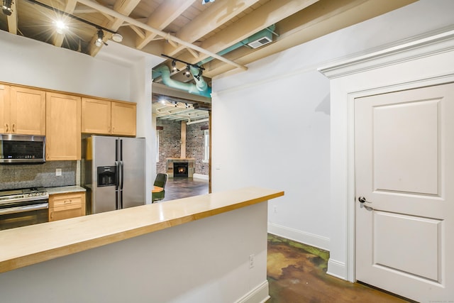 43 Chestnut St Unit 106, New Haven, CT 06511 - kitchen featuring appliances with stainless steel finishes, rail lighting, decorative backsplash, a wood stove, and a wooden ceiling with exposed beams