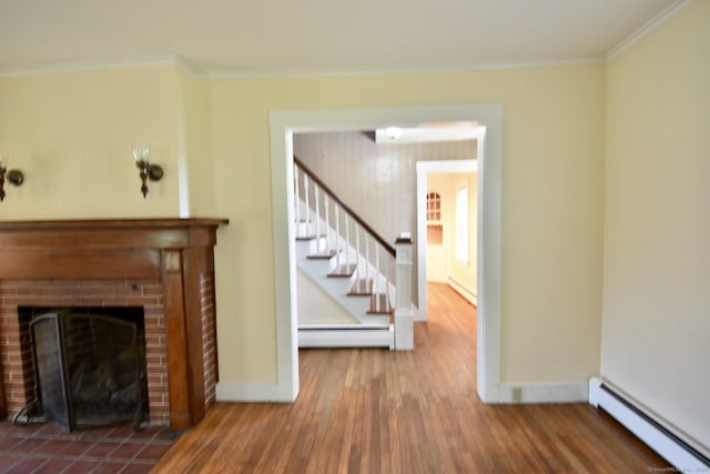 living area with baseboards, a baseboard radiator, wood finished floors, and ornamental molding
