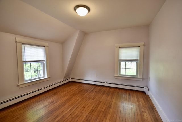 additional living space featuring a baseboard radiator, plenty of natural light, and hardwood / wood-style flooring