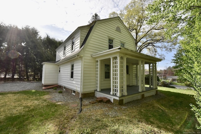 view of property exterior featuring a gambrel roof and a yard