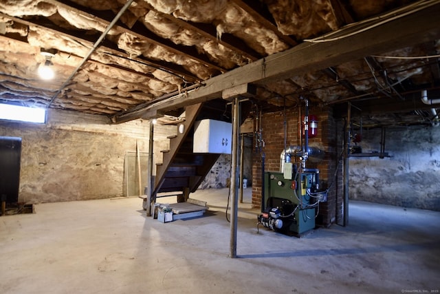 below grade area featuring stairs, a heating unit, and heating fuel