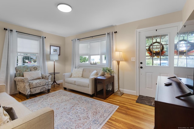 living room with baseboards and light wood-style flooring