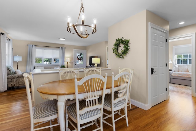 dining space featuring recessed lighting, baseboards, wood finished floors, and a chandelier