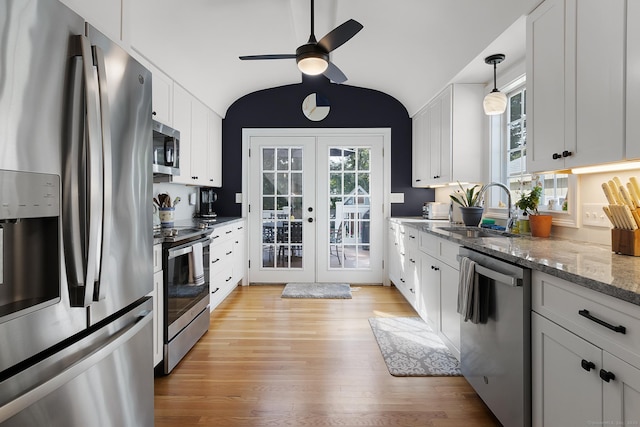 kitchen featuring a ceiling fan, french doors, appliances with stainless steel finishes, a sink, and light wood-style flooring