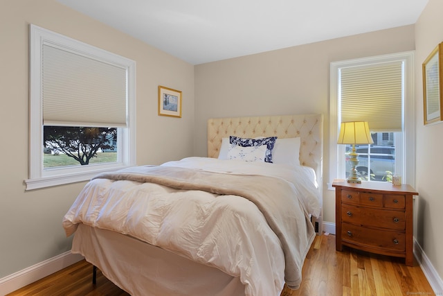bedroom with baseboards and wood finished floors