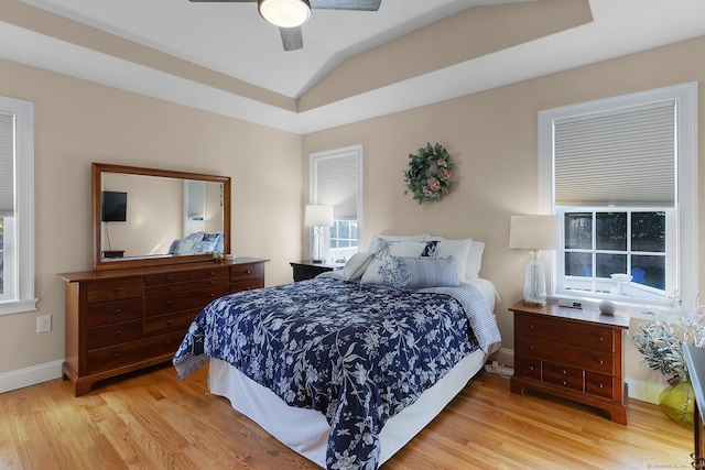 bedroom with baseboards, a ceiling fan, and light wood-style flooring