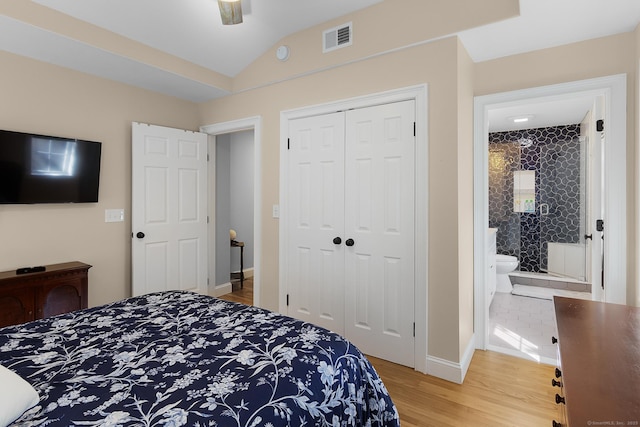 bedroom with lofted ceiling, a closet, visible vents, light wood-style flooring, and baseboards