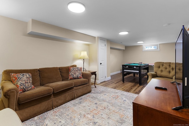 living area with baseboards and wood finished floors