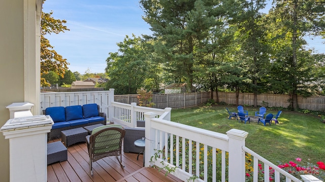 deck with a lawn, a fenced backyard, and an outdoor living space with a fire pit