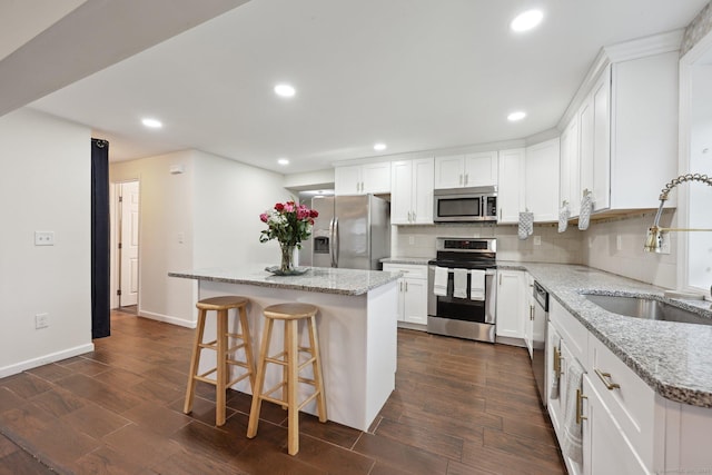 38 Broad St, Plainville, CT 06062 - kitchen with appliances with stainless steel finishes, a sink, a center island, recessed lighting, and white cabinets