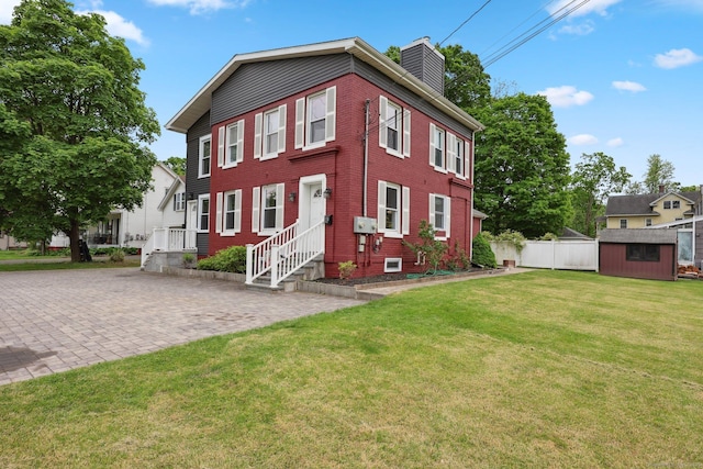 38 Broad St, Plainville, CT 06062 - view of front facade featuring a chimney, a storage shed, an outdoor structure, and brick siding