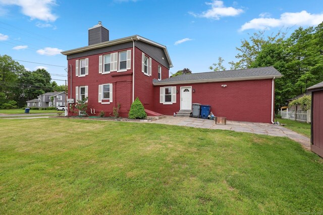 38 Broad St, Plainville, CT 06062 - rear view of property featuring entry steps, a chimney, brick siding, and a patio area