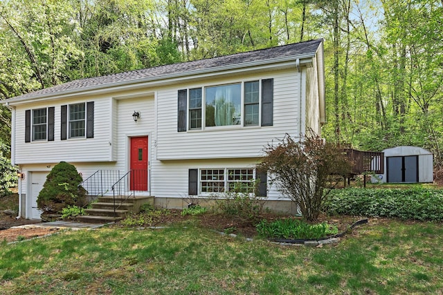 split foyer home with a storage shed, an outbuilding, an attached garage, and a front yard