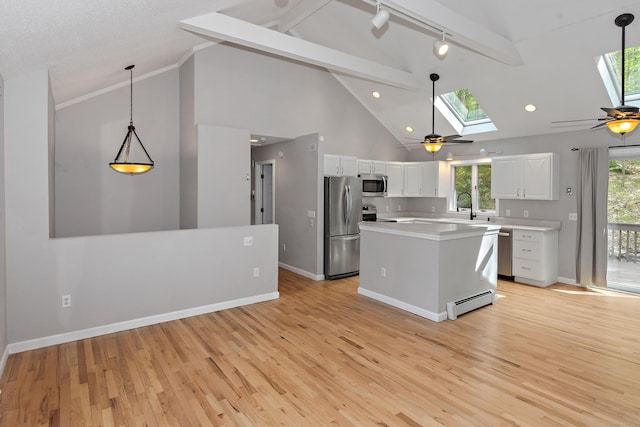 kitchen with ceiling fan, light countertops, white cabinetry, a skylight, and stainless steel appliances