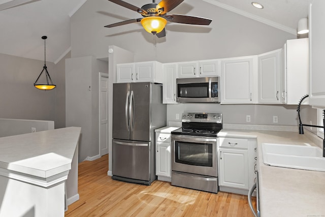 kitchen featuring a ceiling fan, appliances with stainless steel finishes, light countertops, light wood finished floors, and lofted ceiling