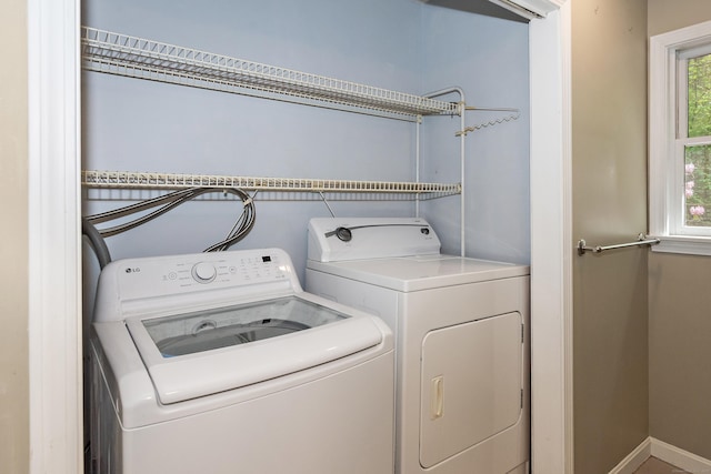 clothes washing area with laundry area, washer and clothes dryer, and baseboards
