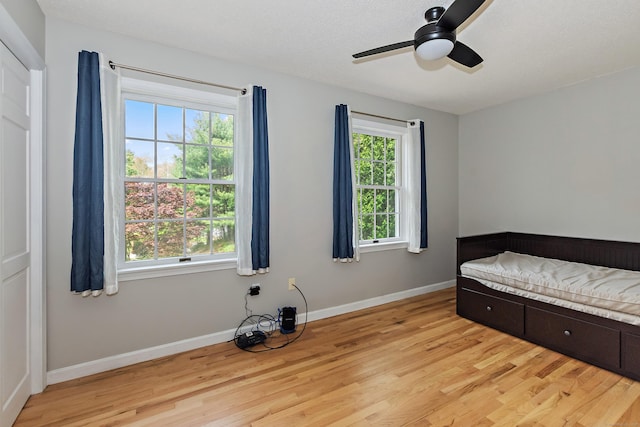 unfurnished bedroom featuring baseboards, a ceiling fan, and light wood-type flooring