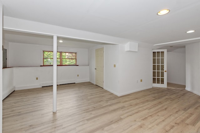 below grade area with recessed lighting, baseboards, a baseboard radiator, and light wood-type flooring