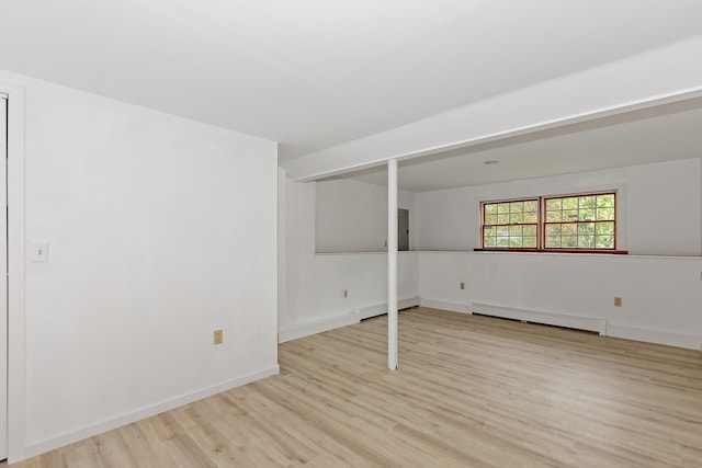 interior space featuring light wood-style floors, a baseboard radiator, and baseboards