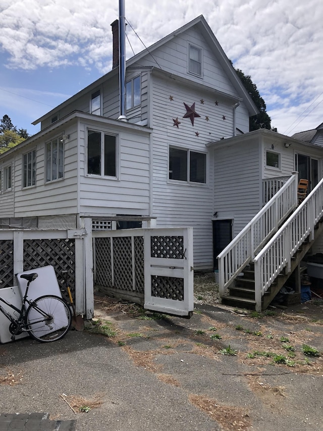 view of property exterior featuring stairs and a chimney
