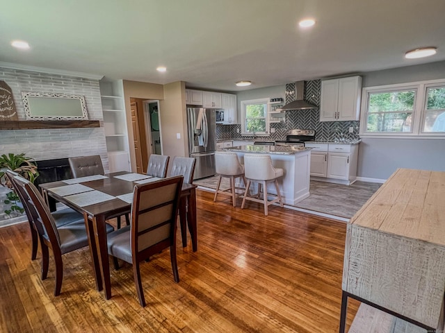 63 Ridgetop Rd, Wallingford, CT 06492 - dining room with dark wood finished floors, a tile fireplace, baseboards, and recessed lighting