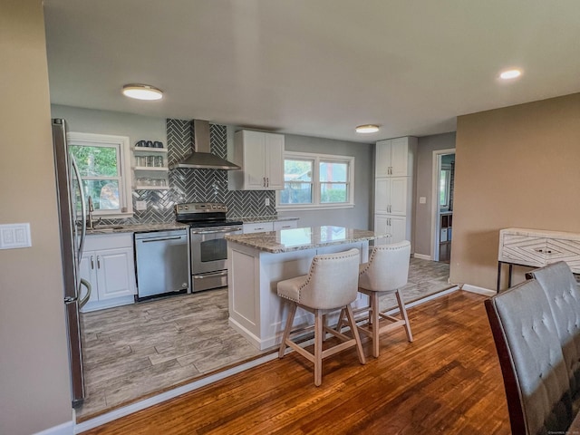 63 Ridgetop Rd, Wallingford, CT 06492 - kitchen with stainless steel appliances, wall chimney range hood, light wood-style flooring, white cabinets, and recessed lighting