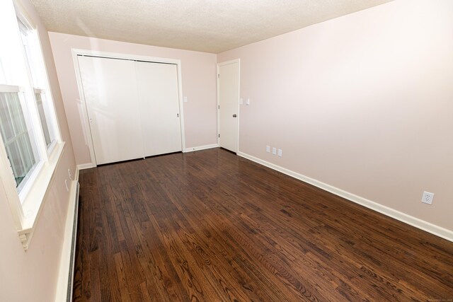 144 Fiesta Hts, Meriden, CT 06451 - unfurnished bedroom featuring dark wood-style flooring, baseboards, and a closet