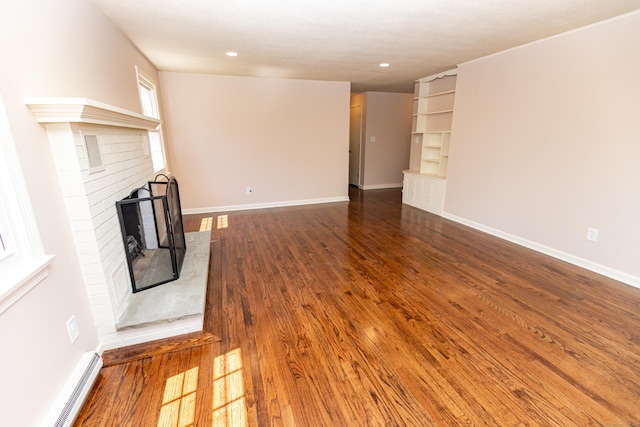 144 Fiesta Hts, Meriden, CT 06451 - unfurnished living room with a baseboard radiator, a brick fireplace, wood finished floors, baseboards, and recessed lighting