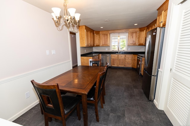 144 Fiesta Hts, Meriden, CT 06451 - kitchen featuring appliances with stainless steel finishes, a chandelier, dark countertops, a wainscoted wall, and a sink