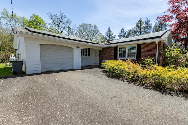 144 Fiesta Hts, Meriden, CT 06451 - single story home featuring roof mounted solar panels, a garage, asphalt driveway, and brick siding