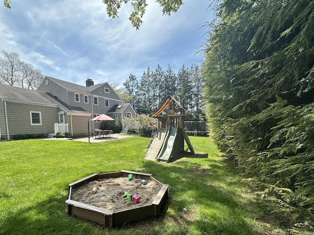 view of yard featuring a patio, a playground, and fence
