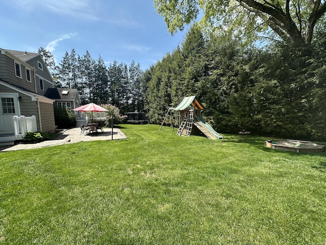 view of yard featuring a playground and a patio area