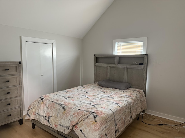 bedroom with baseboards, light wood-style flooring, and lofted ceiling