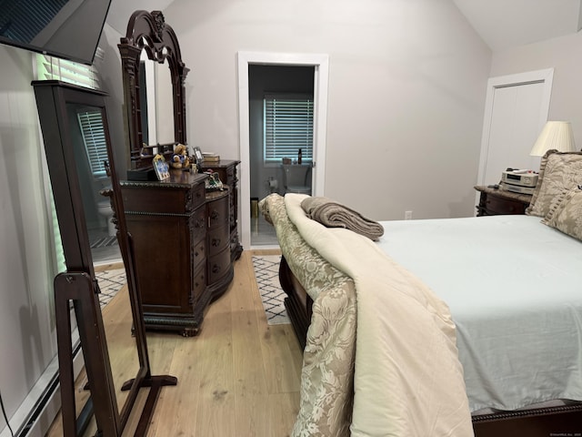 bedroom with light wood-type flooring and lofted ceiling
