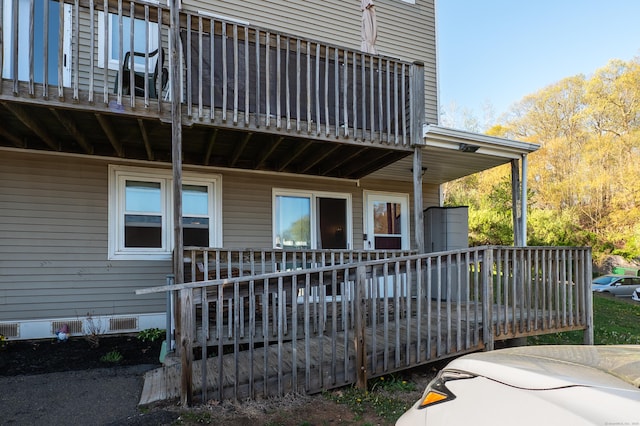 back of house with a balcony, a wooden deck, and crawl space