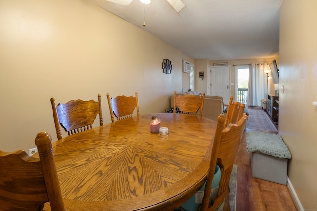 dining area featuring baseboards, a ceiling fan, and wood finished floors