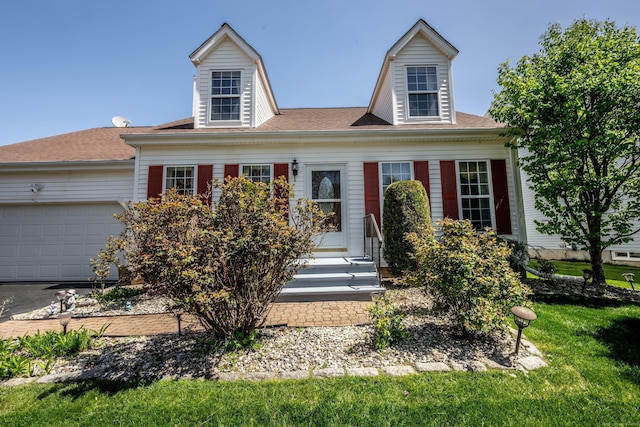 new england style home featuring a garage, entry steps, and aphalt driveway