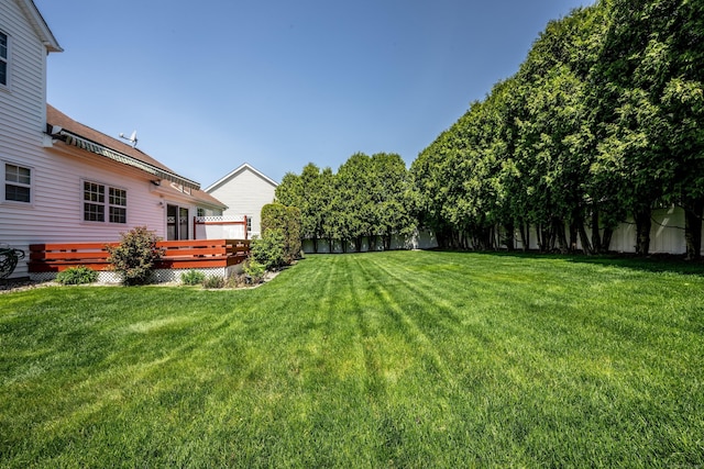 view of yard featuring fence and a deck
