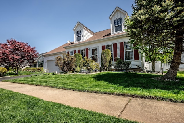 cape cod home with an attached garage, fence, driveway, and a front lawn