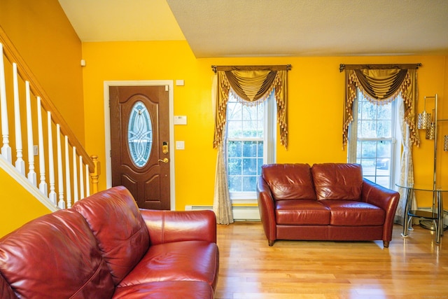 living room featuring plenty of natural light, wood finished floors, and stairway