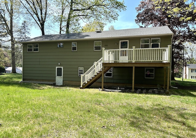 back of property with stairway, a yard, and a wooden deck