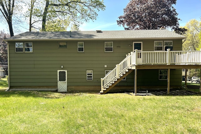 rear view of property featuring stairs, a lawn, and a deck