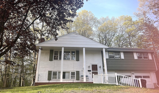 raised ranch with a garage, a chimney, and a porch