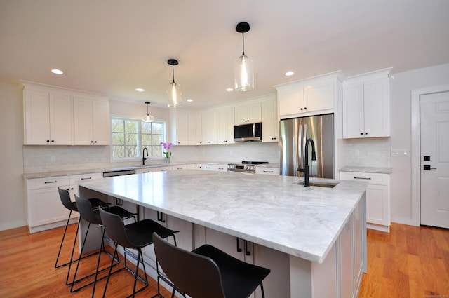 kitchen featuring a sink, white cabinetry, appliances with stainless steel finishes, and a kitchen island