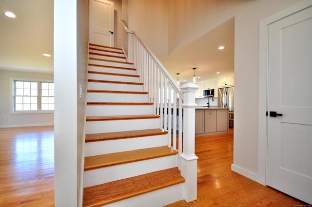 stairs with recessed lighting, baseboards, and wood finished floors