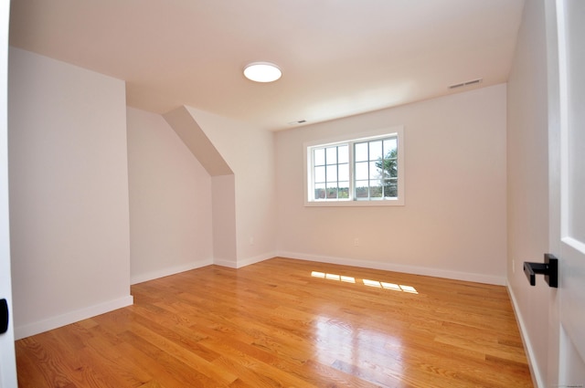 bonus room with baseboards, visible vents, and light wood-style floors