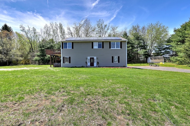 104 S St, Morris, CT 06763 - colonial house featuring a front lawn, cooling unit, a wooden deck, and solar panels