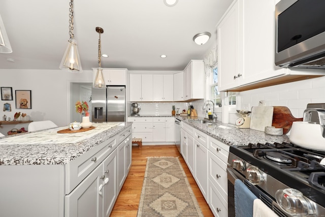 26 Greenwood Dr, Prospect, CT 06712 - kitchen with appliances with stainless steel finishes, tasteful backsplash, a sink, white cabinets, and light wood-style flooring