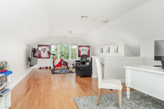 interior space with visible vents, baseboards, wood finished floors, and vaulted ceiling