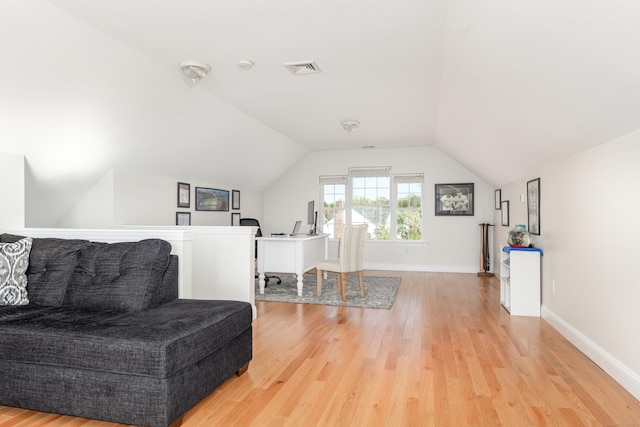 interior space featuring baseboards, light wood-style flooring, and lofted ceiling
